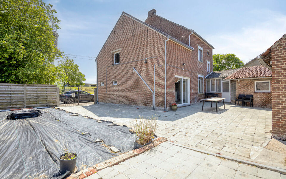 Ben je op zoek naar een woning met karakter &eacute;n mogelijkheden?
Dan is deze open bebouwing in het landelijke Kortenaken absoluut het ontdekken waard.

Deze charmante woning (ca. 214 m&sup2;), oorspronkelijk gebouwd rond 1907 en nadien stapsgewijs gerenoveerd, 